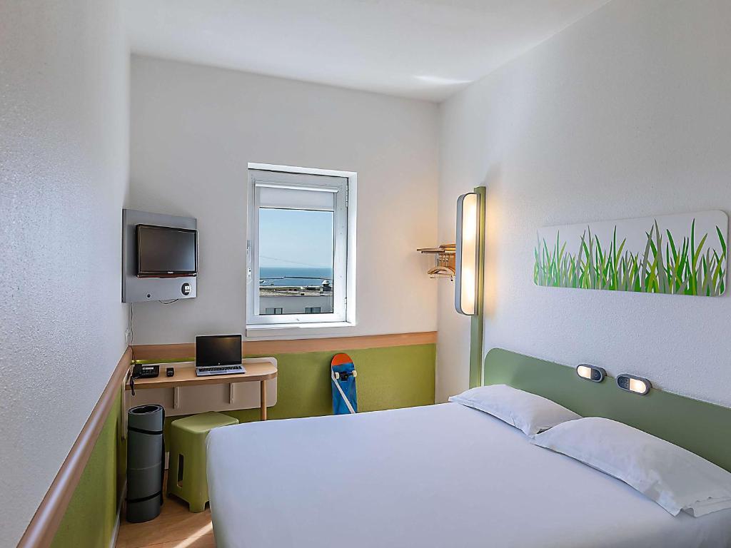 a bedroom with a bed and a desk and a window at Hotel ibis Budget Porto Gaia in Vila Nova de Gaia