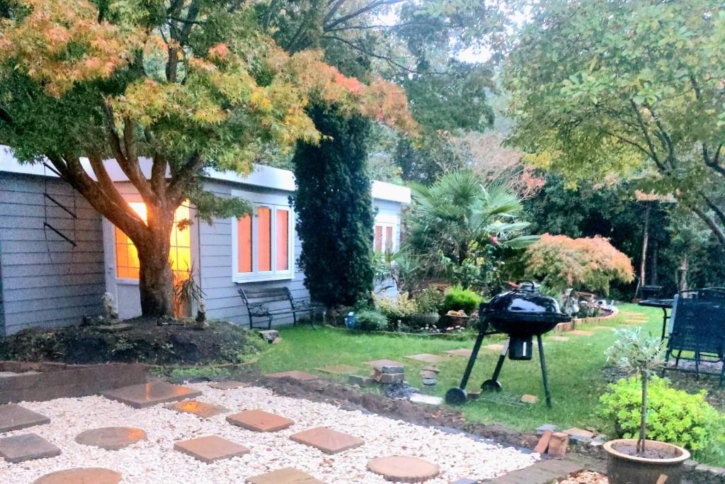 a grill in the yard of a house at Beautiful Peaceful Cottage Overlooking The Museum in Weybridge