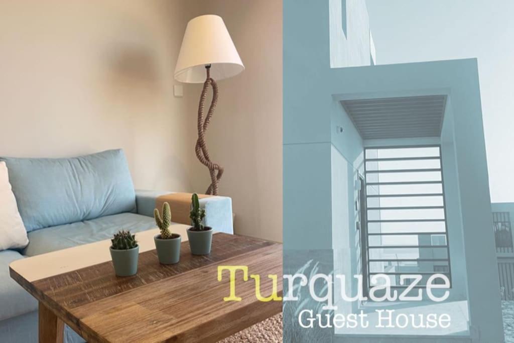 Turquaze Guesthouse في مسقط: غرفة معيشة مع أريكة وطاولة