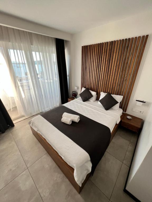 a bedroom with a large bed with a wooden headboard at EXEN BY WEEKEND in Bodrum City