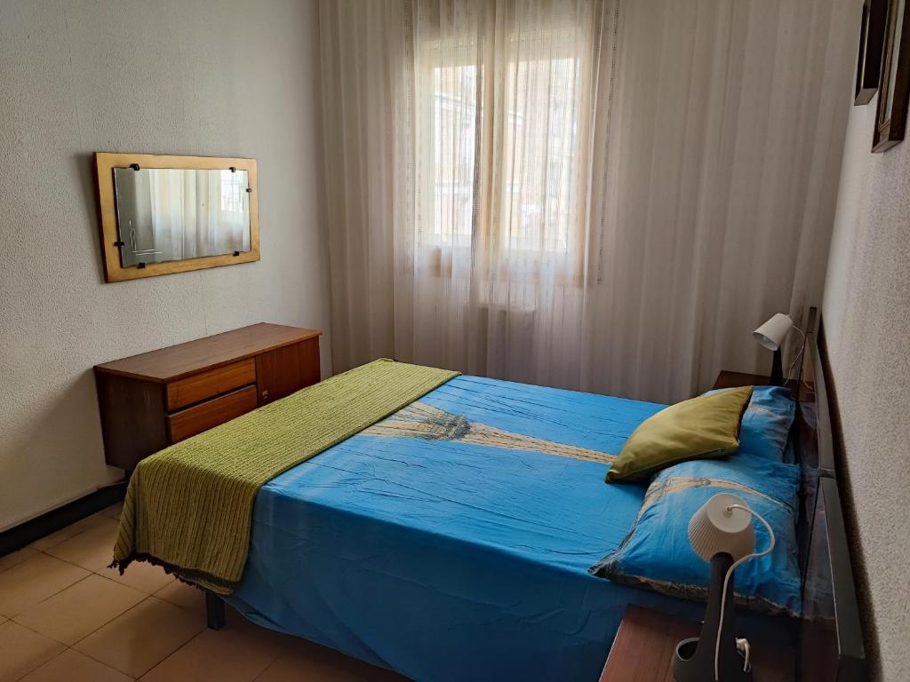 a bedroom with a blue bed and a mirror at Piso temporal Barcelona in Barcelona