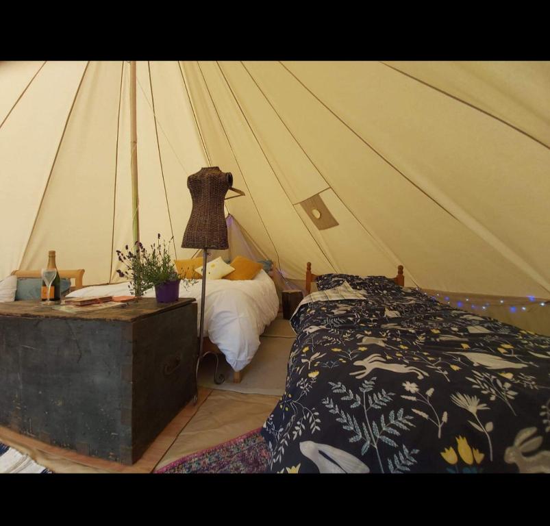 a bedroom with a tent with a bed and a lamp at Blackberry Patch in Pont Yates