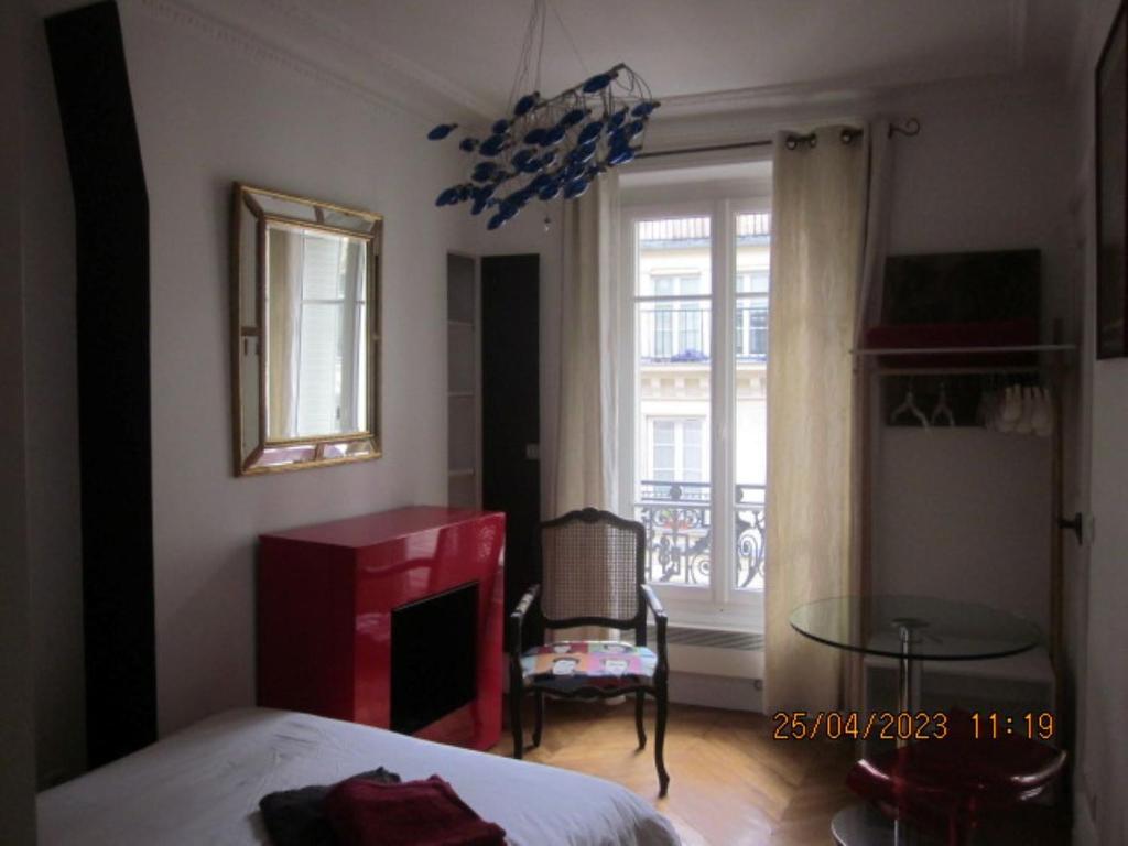 a bedroom with a bed and a fireplace and a window at Bed and Breakfast Paris Centre in Paris