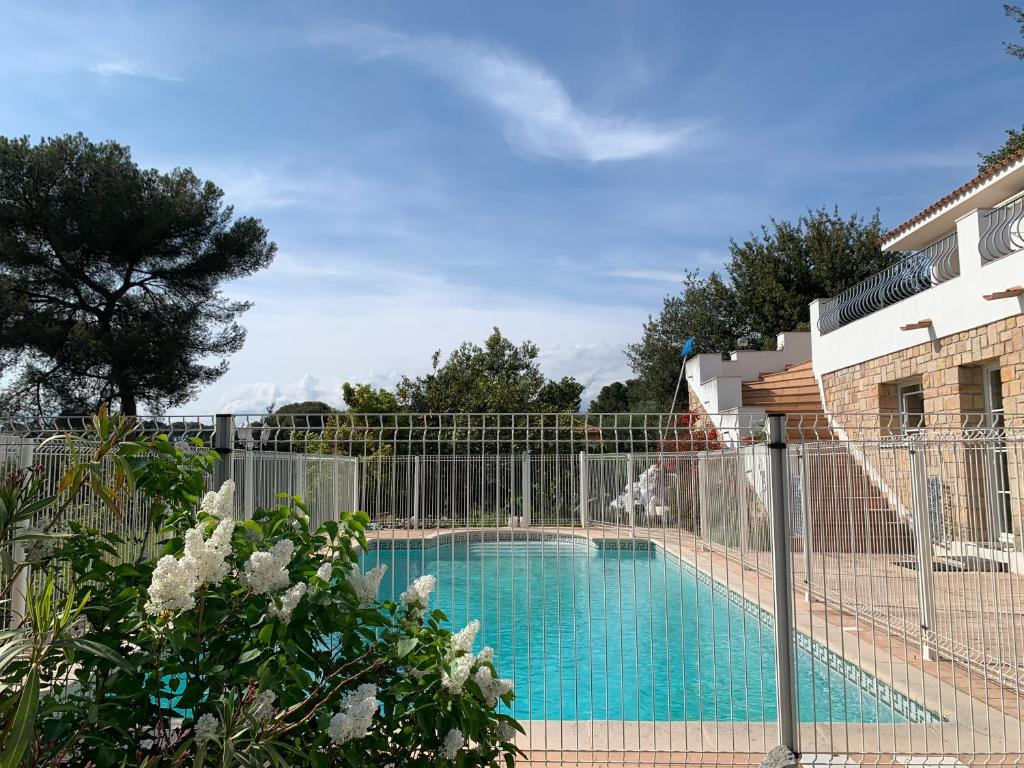 a fence around a swimming pool in a yard at Brise des Pins in Le Cannet