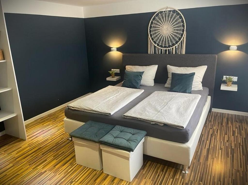 1 dormitorio con 2 camas y pared azul en Unsere Unterkünfte Ferienwohnung Superior für 1-4 Personen und Cozy Apartment für 1-2 Personen, en Goslar