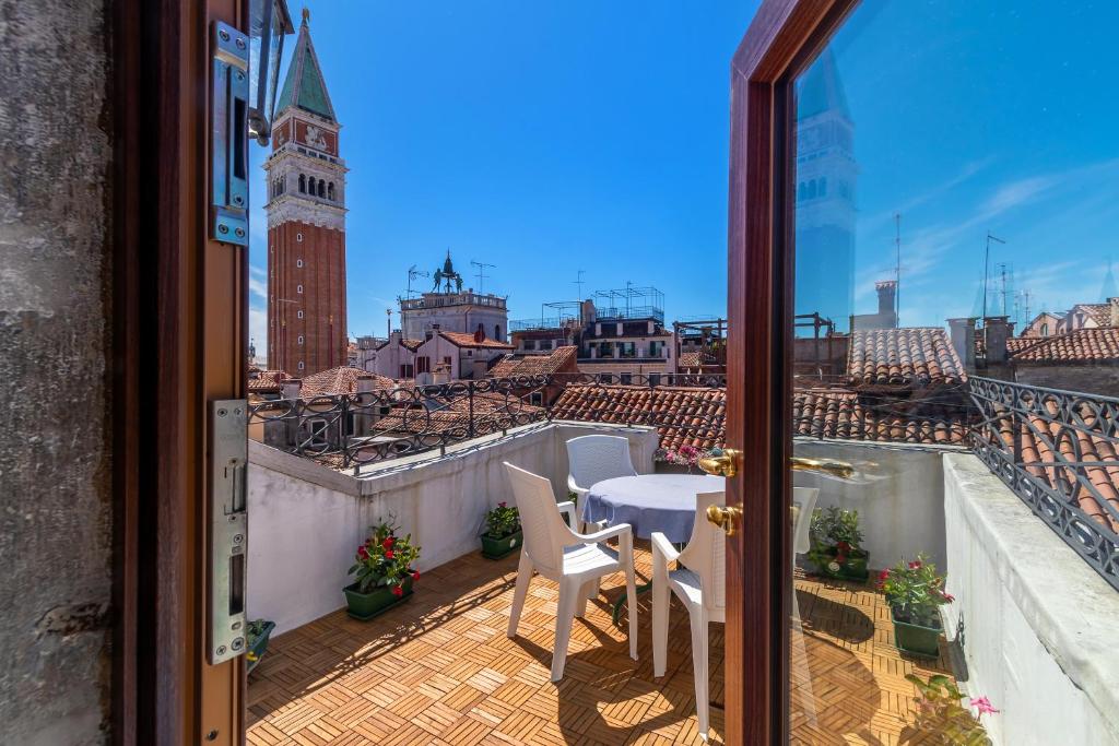 einen Balkon mit einem Tisch und Stühlen sowie Stadtblick in der Unterkunft Hotel ai do Mori in Venedig