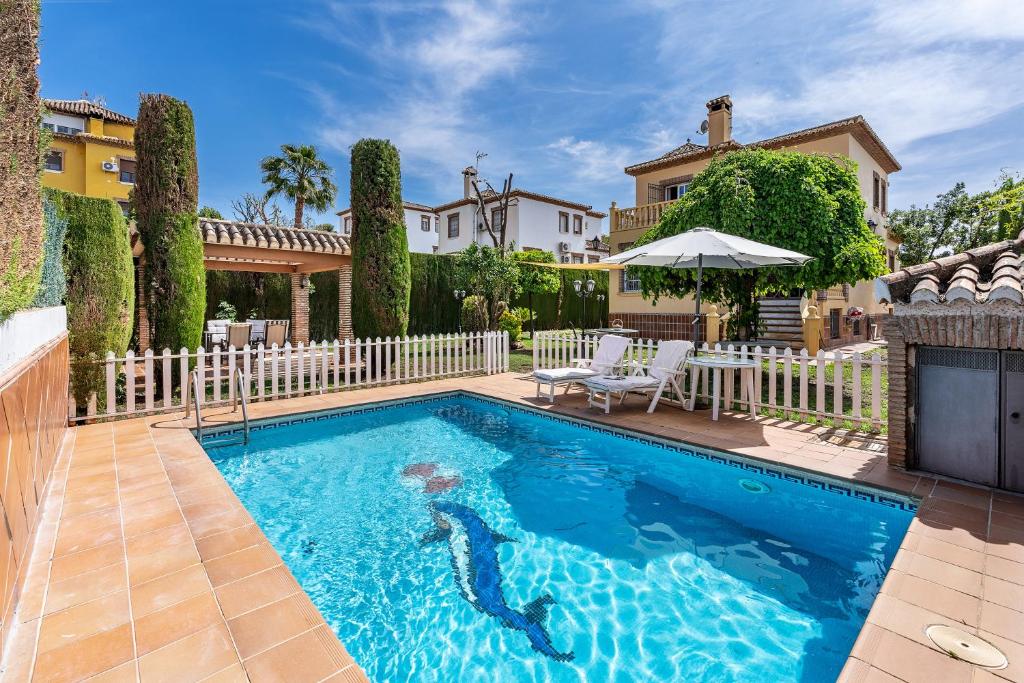 a swimming pool in front of a house at Cypress House in La Zubia