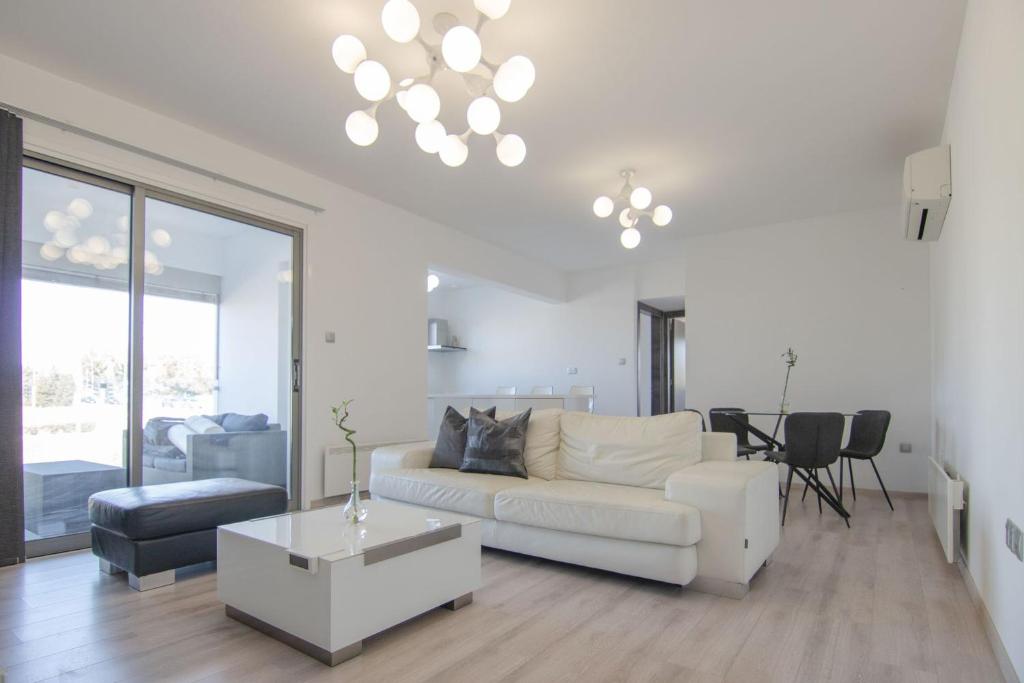 a living room with a white couch and a table at Phaedrus Living: City Flat Rafaella 6 in Nicosia