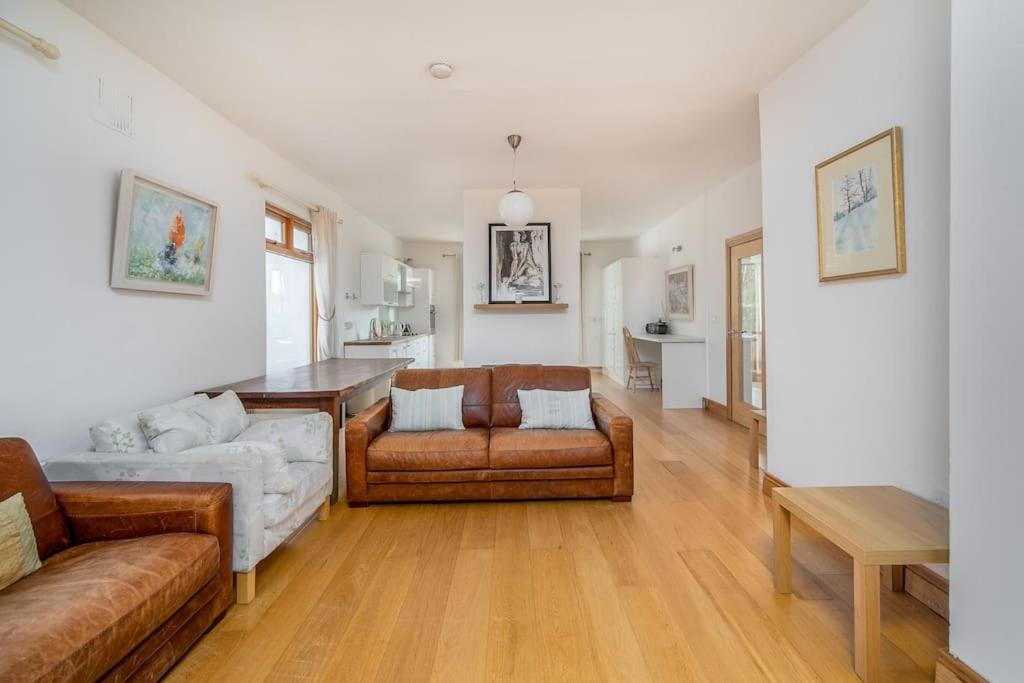 a living room with two couches and a table at The Moorings- near the sea in Tramore