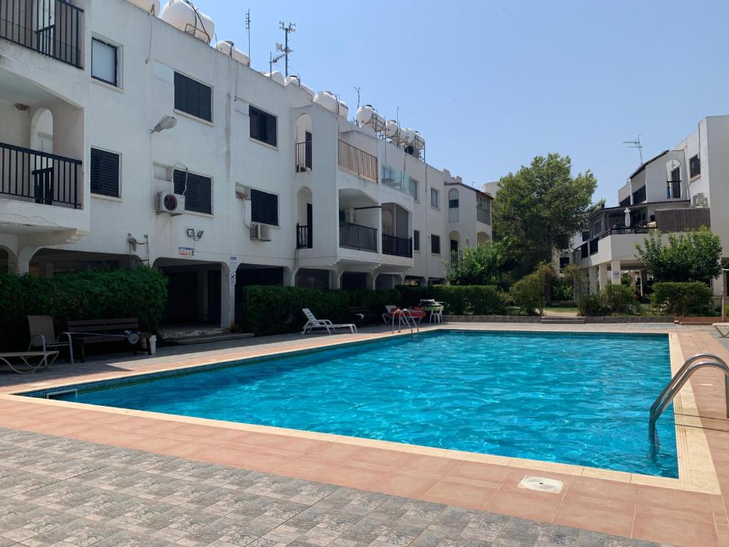 a swimming pool in front of a building at Theodoros Apt.79 in Paralimni