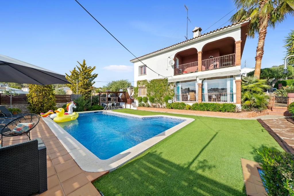 a swimming pool in front of a house at Villa Maravillosa in Cunit