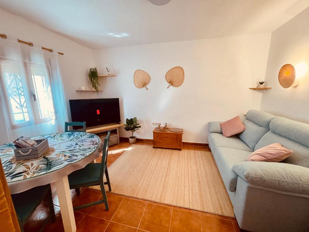 ein Wohnzimmer mit einem blauen Sofa und einem Tisch in der Unterkunft Casa Lucia Albaicin con terraza in Granada