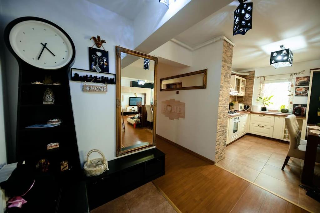 - un salon avec une horloge et un miroir dans l'établissement Apartament Lux Crialy - self check-in, à Timişoara