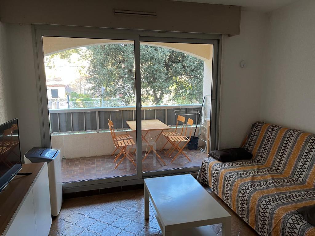 - un salon avec un canapé et une table sur un balcon dans l'établissement STUDIO SAINT MANDRIER, à Saint-Mandrier-sur-Mer