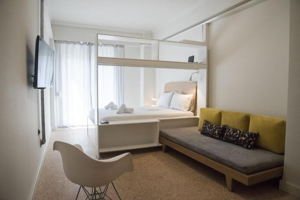 een slaapkamer met een bed, een stoel en een spiegel bij Syntagma View Apartment in Athene