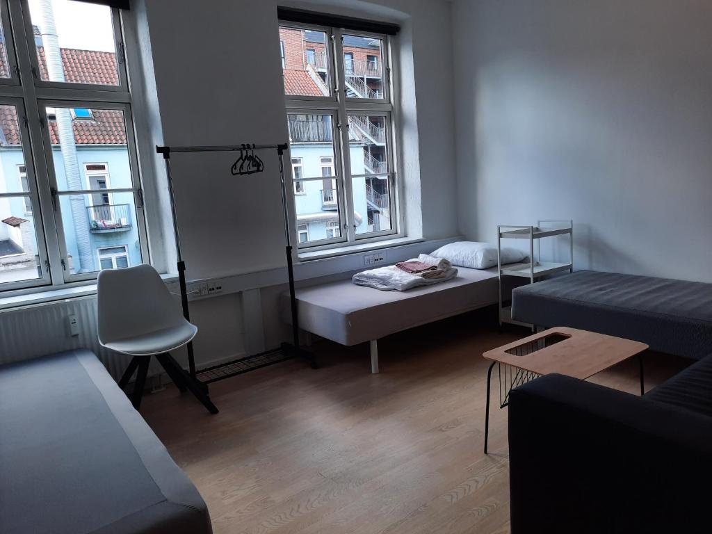 Cette petite chambre comprend un lit et deux fenêtres. dans l'établissement 1- Bed Private room in apartment, à Odense