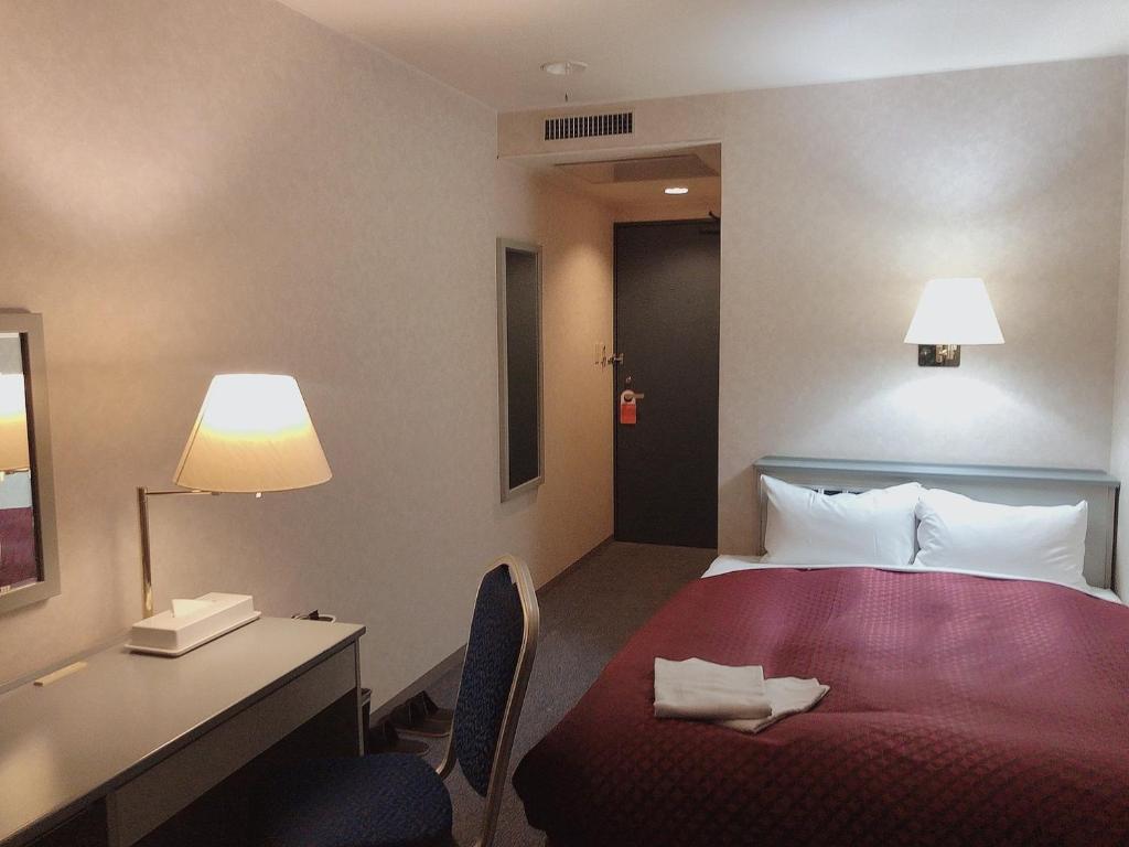 Postel nebo postele na pokoji v ubytování Seagrande Shimizu Station Hotel