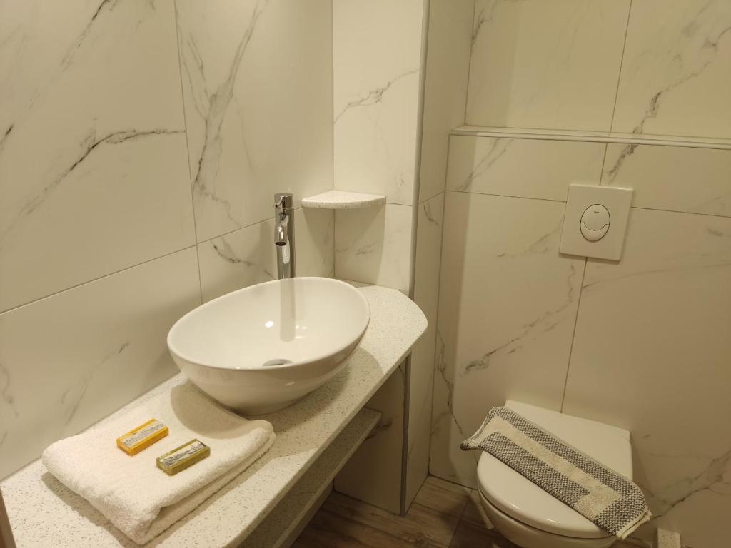 a white bathroom with a sink and a toilet at Filoxenia Studios 1 in Palaiochóra