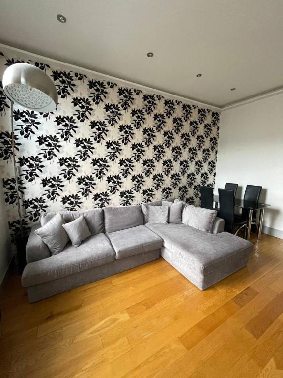 a living room with a couch and a wall with black and white wallpaper at Stylish 1BD Flat - 1 Min from Bethnal Green in London
