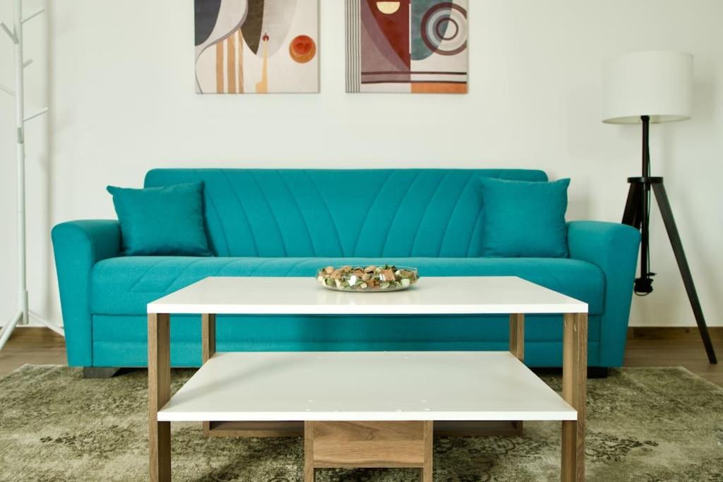 a living room with a blue couch and a table at Residenza dei Molini Monza centro in Monza