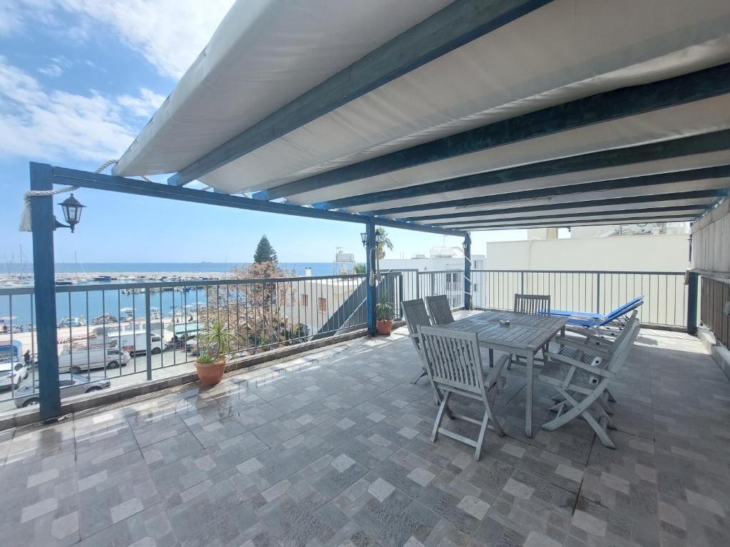 a patio with a table and chairs on a balcony at Penthouse with roof garden in Zygi village Marina in Larnaca
