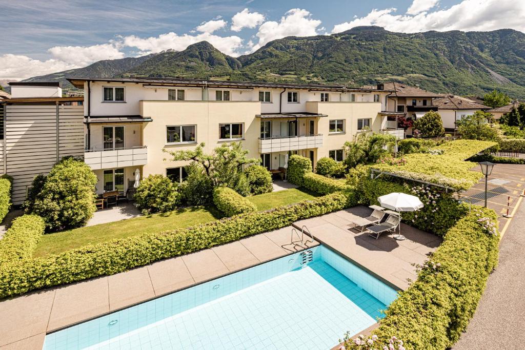 einem Luftblick auf ein Gebäude mit einem Pool in der Unterkunft Garden Residence in Lana