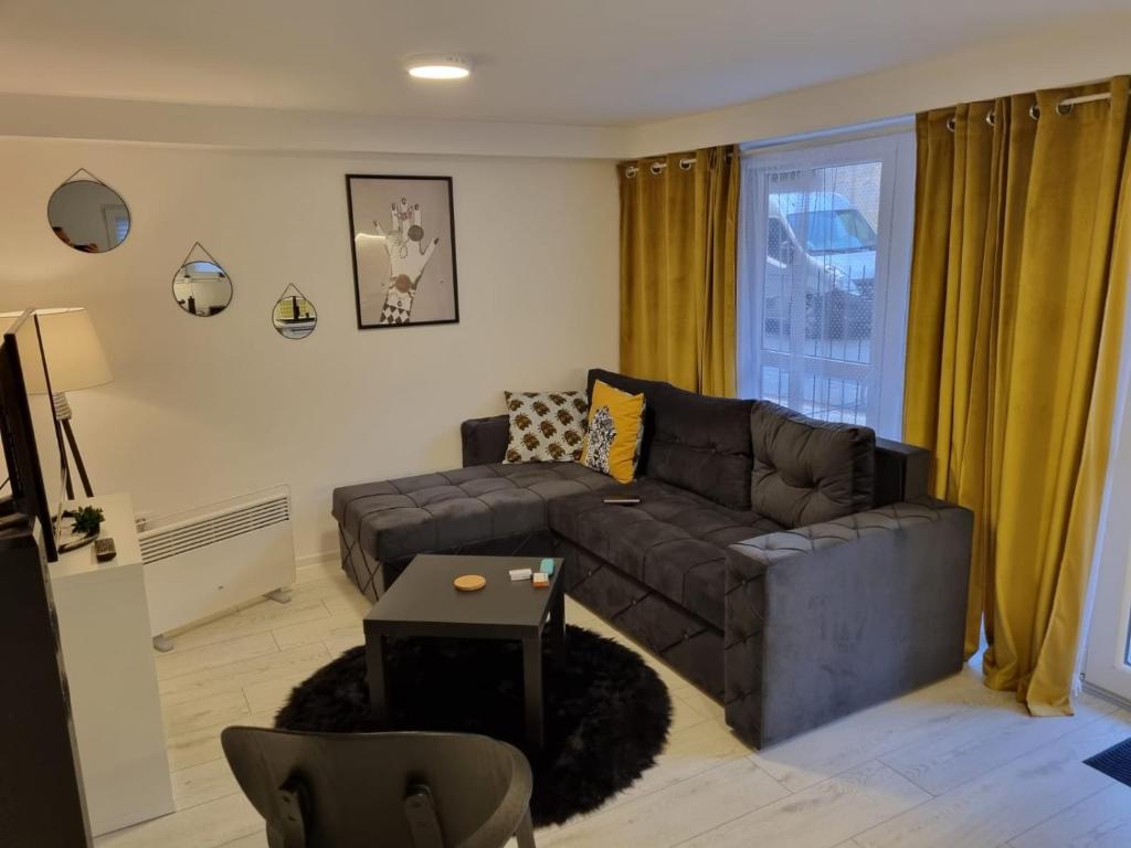 ein Wohnzimmer mit einem Sofa und einem Tisch in der Unterkunft Bowler Hat Apartment Belgrade in Zvezdara