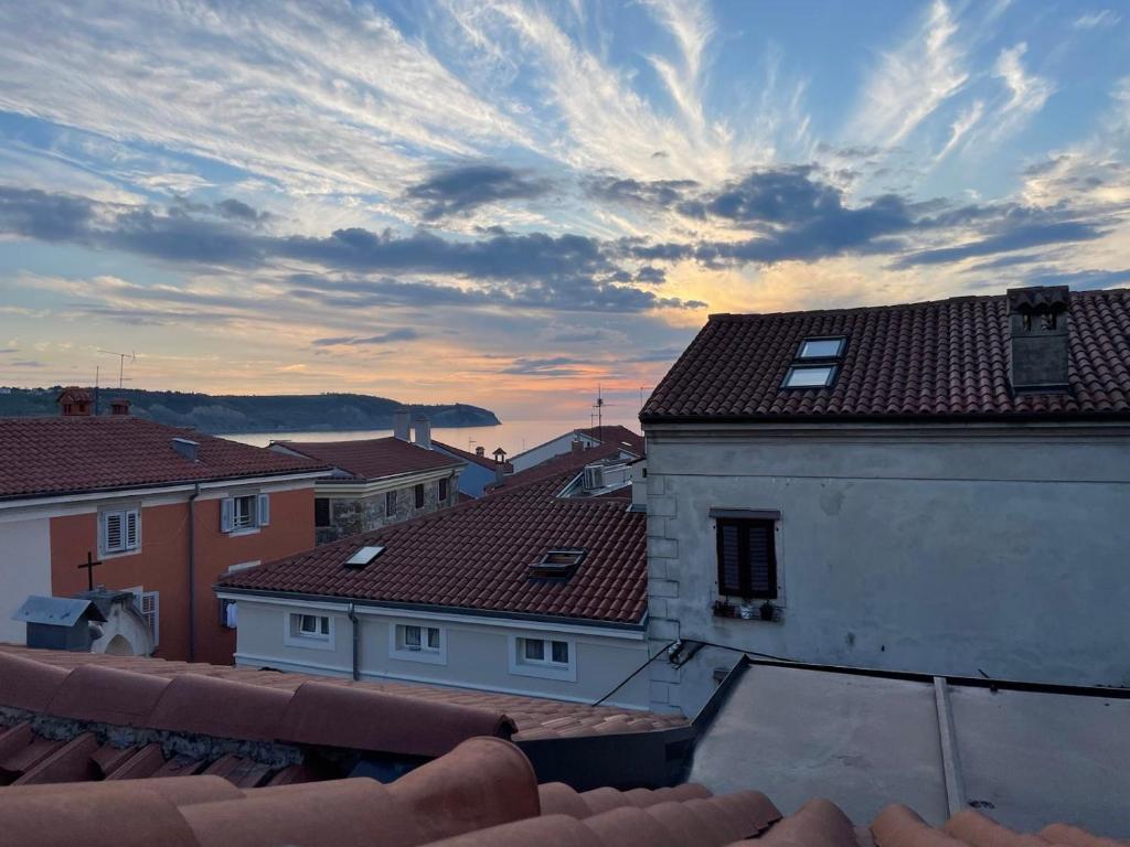 a view of roofs of buildings with a cloudy sky at Apartmaji Sara, Izola - Isola in Izola