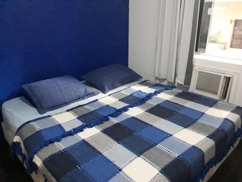 Un dormitorio azul con una cama con paredes azules y una ventana en Apt inteiro 1 minuto da praia, en Río de Janeiro