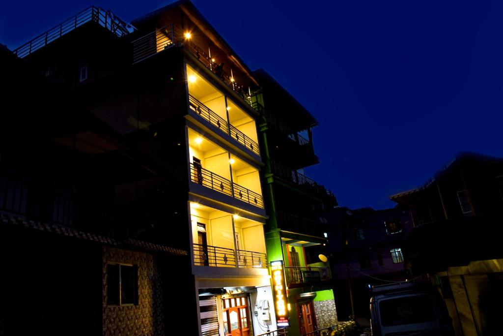 um edifício com luzes de lado à noite em Lava Hotel Aashiyana em Lava
