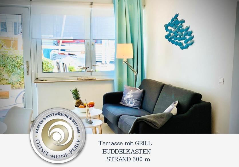 - un salon avec un canapé bleu et une fenêtre dans l'établissement FeWo STRANDGUT- Familien - Hunde - strandnah - eigene Terrasse - Sauna & Wellness, à Sierksdorf
