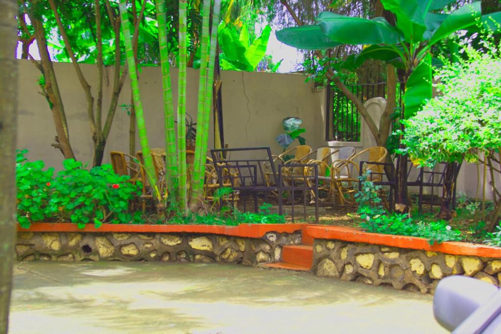 a group of chairs and tables in a garden at Ariel comfort home in Arusha