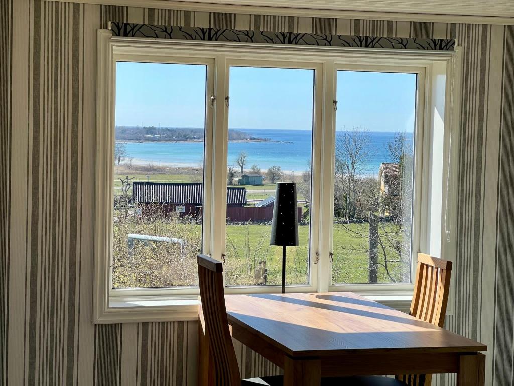 a table and chairs in front of a large window at Klinta sea view in Köpingsvik