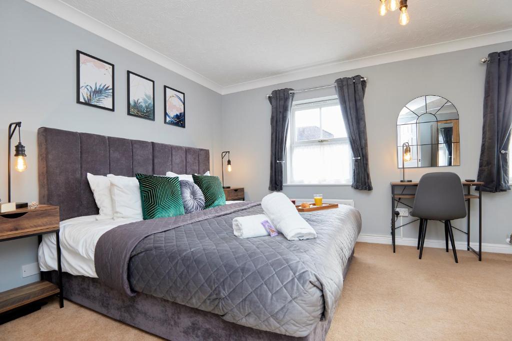 a bedroom with a large bed and a desk at Evergreen House - Modern 4-bed Family, Contractors, Free Netflix, Fast WiFi, NEC, Resorts World, JLR, Airport in Solihull