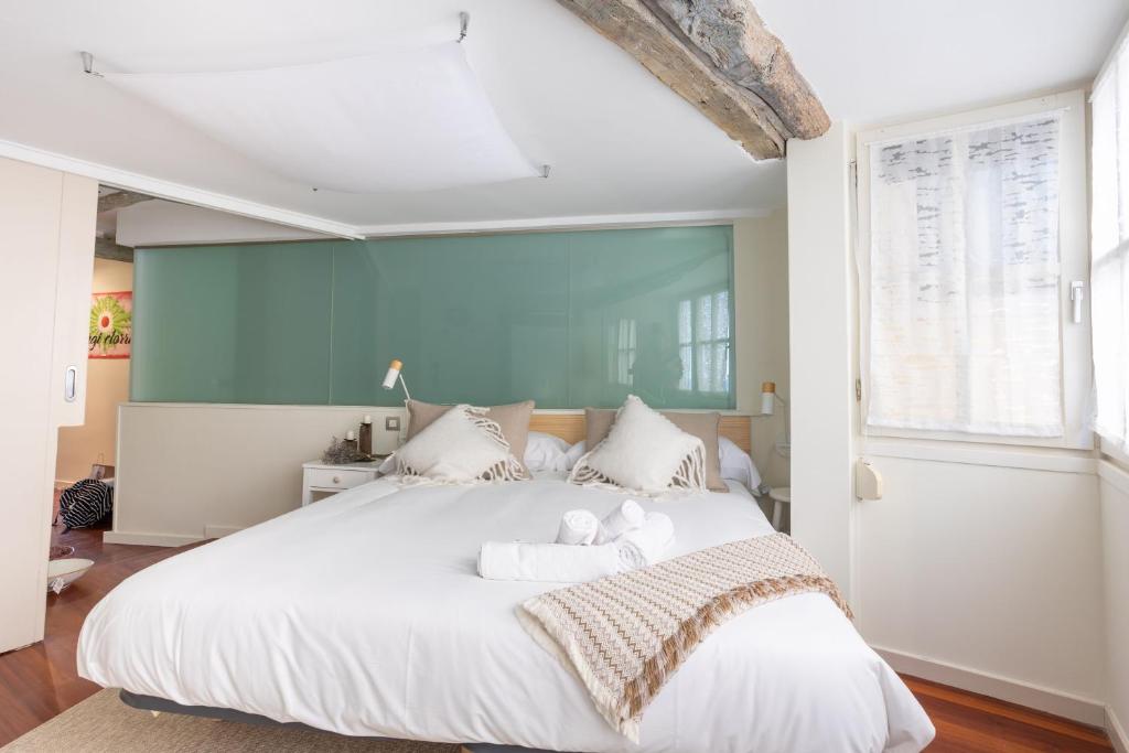 een slaapkamer met een groot wit bed met 2 teddyberen erop bij IZARO BEST VIEW By Urdaibai Rentals in Bermeo