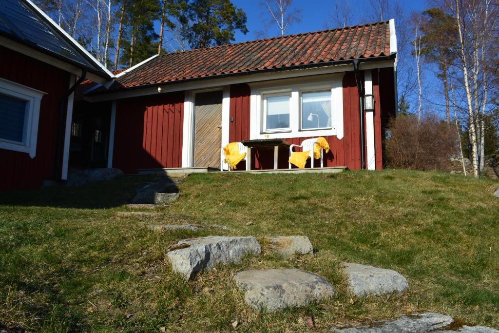 une maison rouge avec deux chaises jaunes devant elle dans l'établissement Sun Slottet, à Stockholm