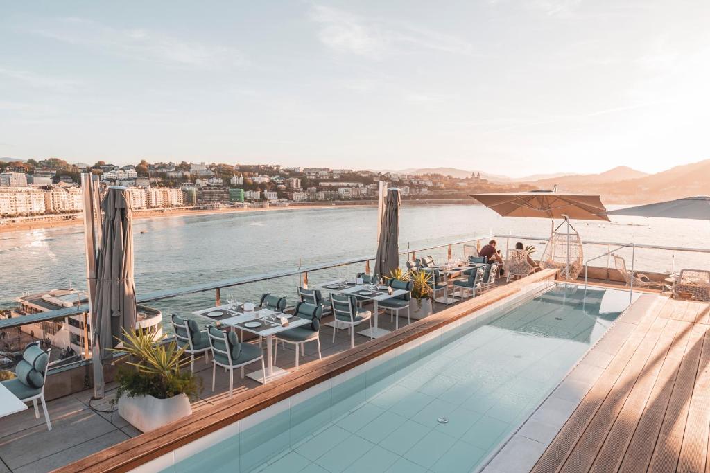 ein Dachrestaurant mit Blick auf das Wasser in der Unterkunft Lasala Plaza Hotel in San Sebastián