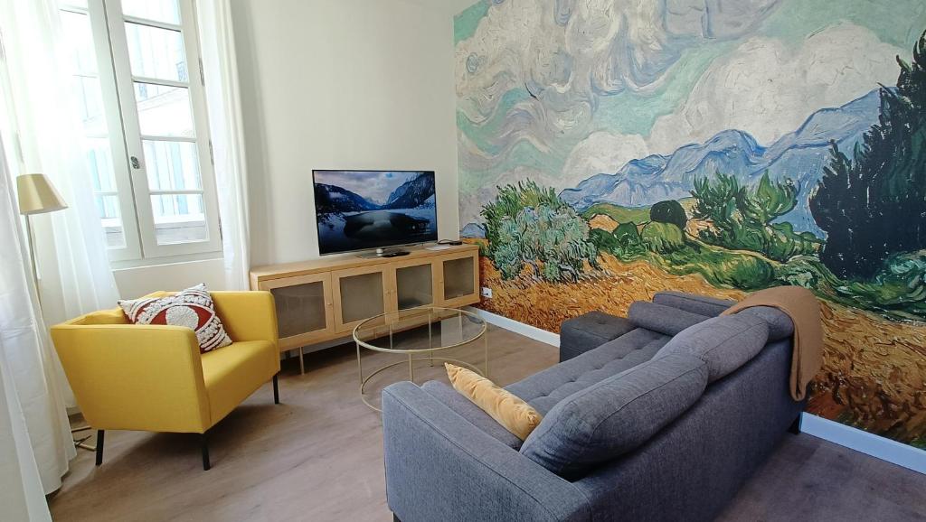 a living room with two couches and a painting on the wall at Dastro Logis in Saint-Rémy-de-Provence