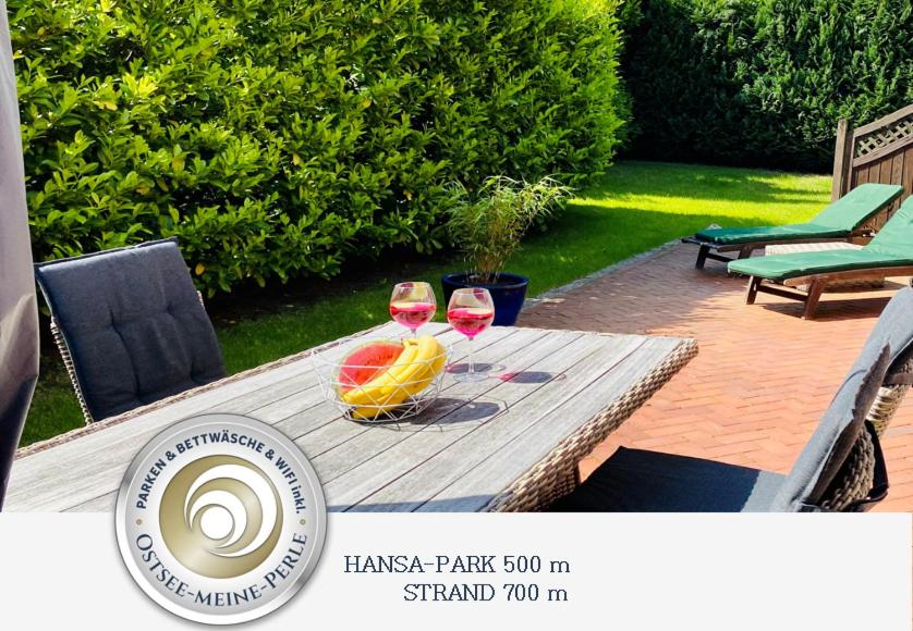 - une table avec deux verres de vin et un bol de fruits dans l'établissement FeWo SONNENDECK Familien-strandnah-Garten-Hunde-Sport-und Schwimmbadnah-HansaPark, à Sierksdorf