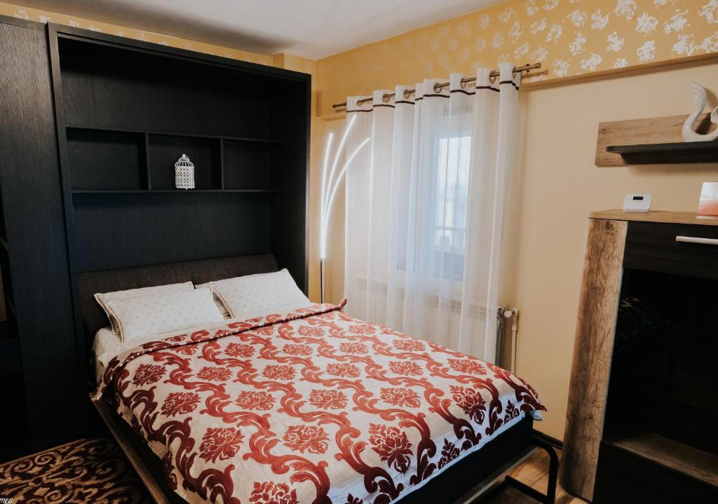 a bedroom with a bed with a red and white comforter at Carla's Studio Central Palas, airport shuttle in Iaşi