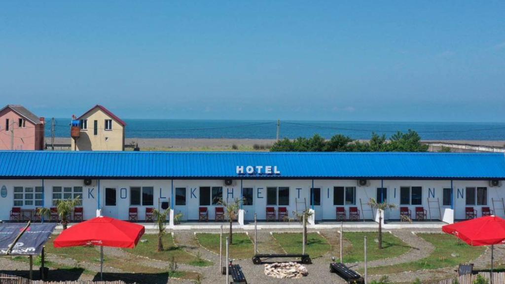 una fila de sombrillas rojas delante de un motel en KOLKHETI JIBO Beach en Grigoleti