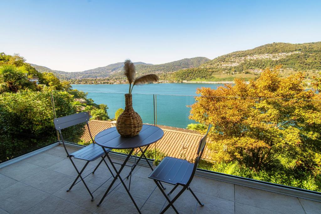 a table and chairs on a balcony with a view of a lake at La Palma 1 by Quokka 360 - modern panoramic lake view flat in Montagnola