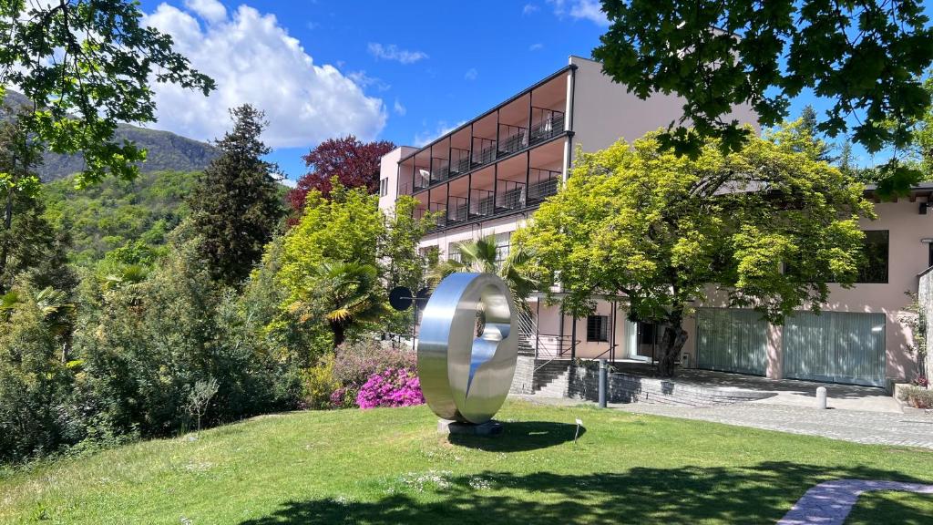 un grande oggetto metallico nell'erba di fronte a un edificio di Hotel Monte Verità ad Ascona