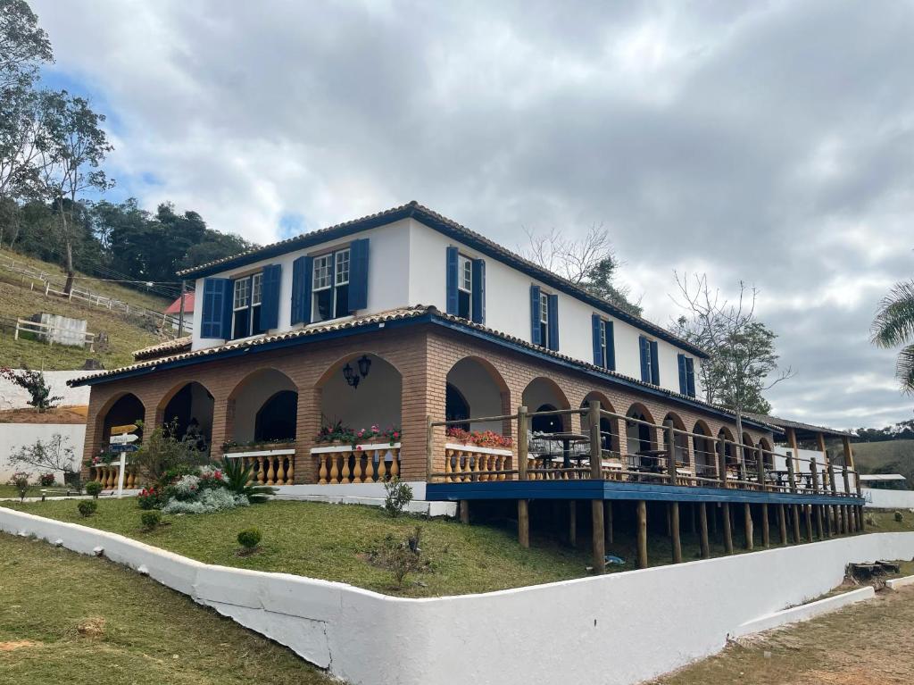 a large house with a wrap around porch at Fascinação Café Hotel in Cunha
