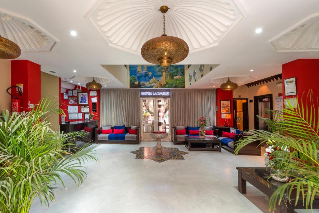 a lobby with red and blue furniture and plants at Le Caspien Boutique Hotel in Marrakech