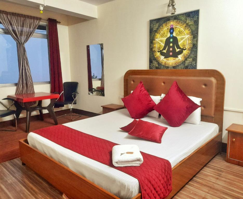 1 dormitorio con 1 cama grande con almohadas rojas en Mysa Maya Homestay, en Darjeeling