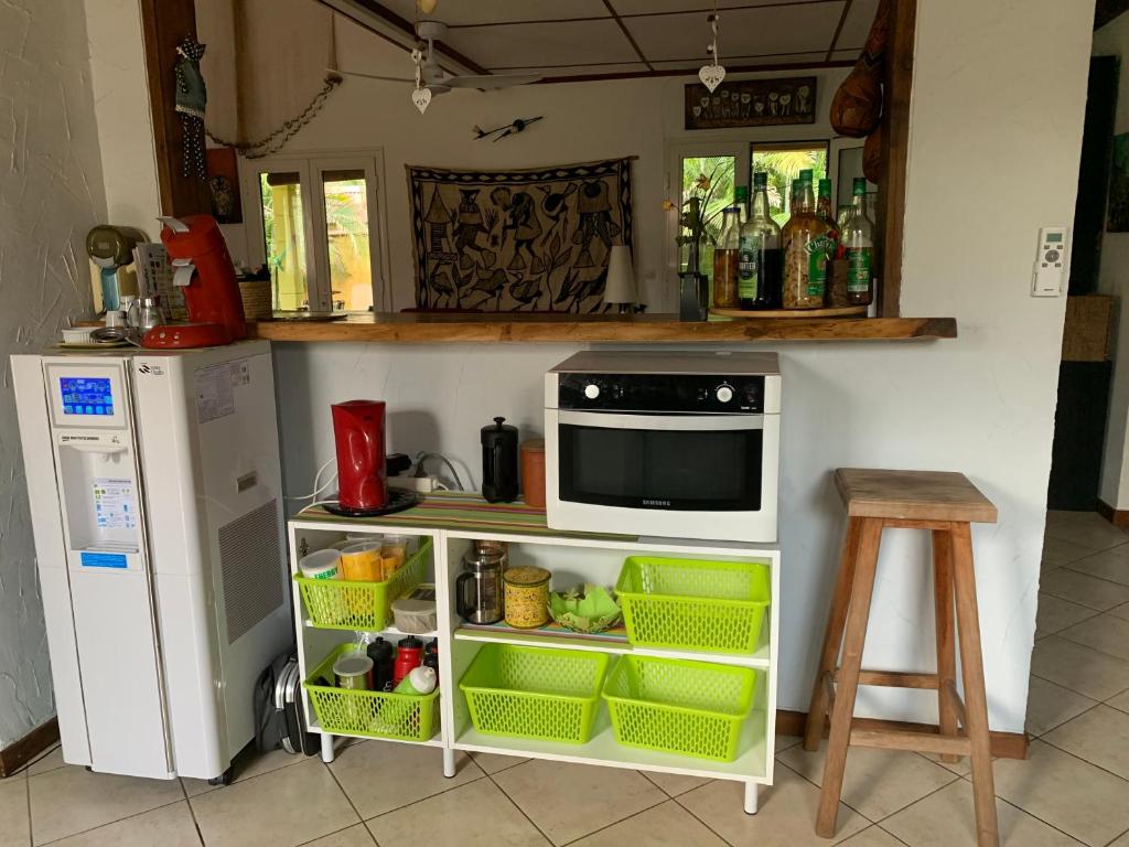 a kitchen with a microwave and a refrigerator at Le Dodo Salé in Étang-Salé