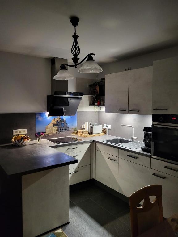 a kitchen with white cabinets and a black counter top at Haus für vier, kinderfreundlich! in Steinhagen