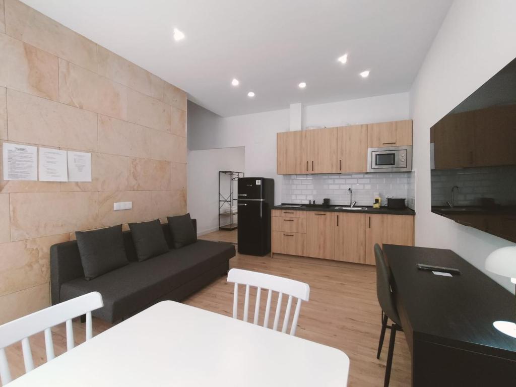sala de estar con sofá y cocina en Apartamentos La Brava by gaiarooms, en Salamanca