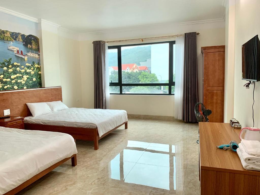 una camera d'albergo con due letti e una finestra di Hotel trung hiếu a Ha Long